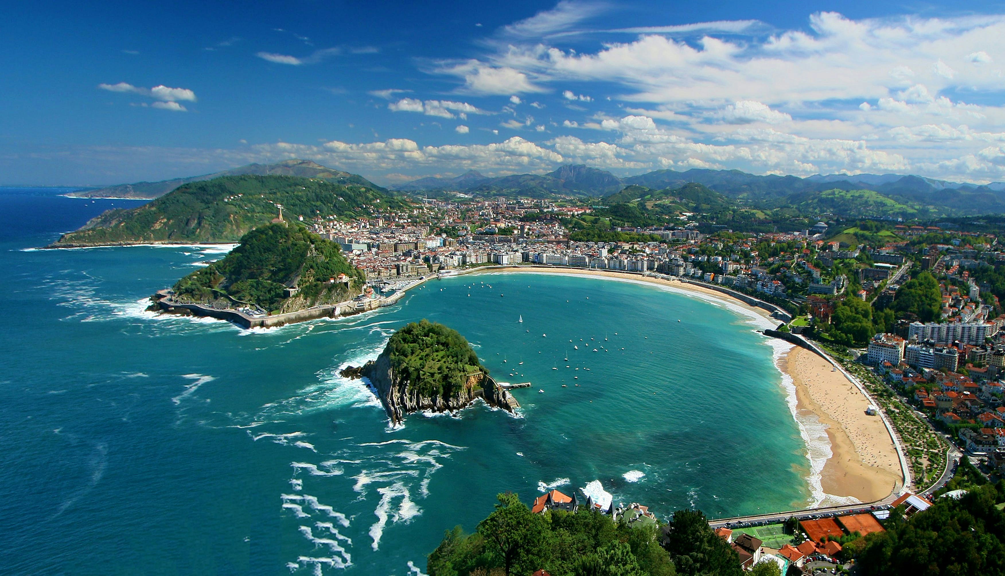 Puerto de San Sebastián con barcos y casas junto al agua