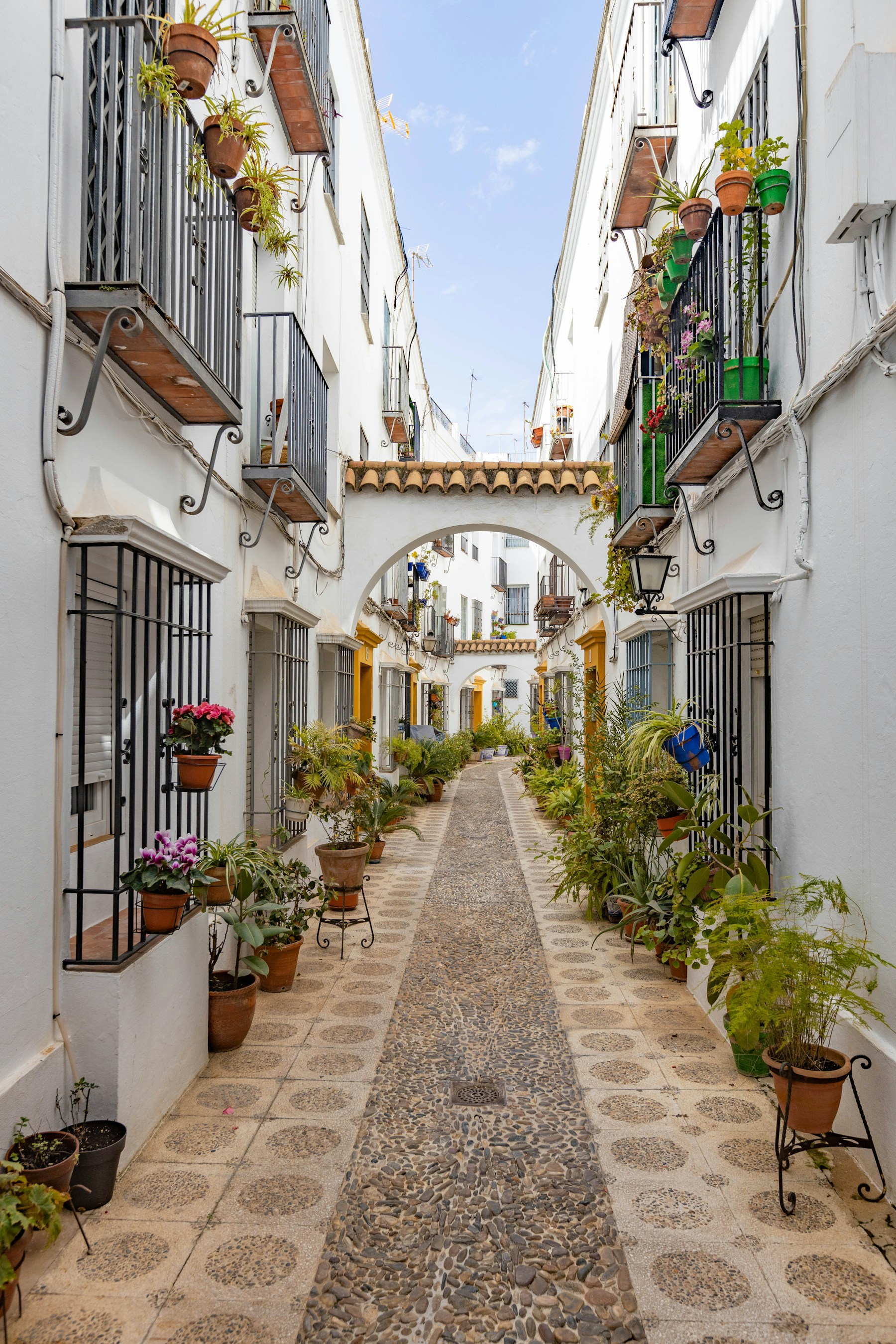 Calle estrecha de Córdoba con macetas azules en las paredes