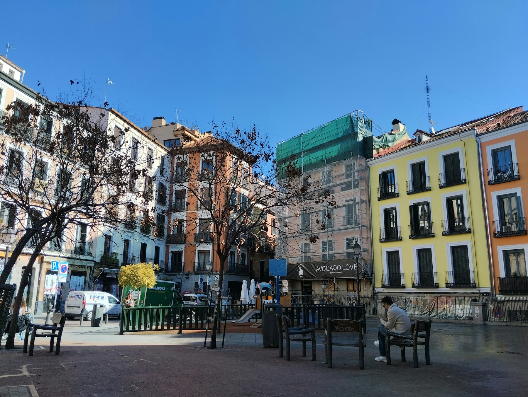Persona sentada en una plaza de Malasaña, Madrid