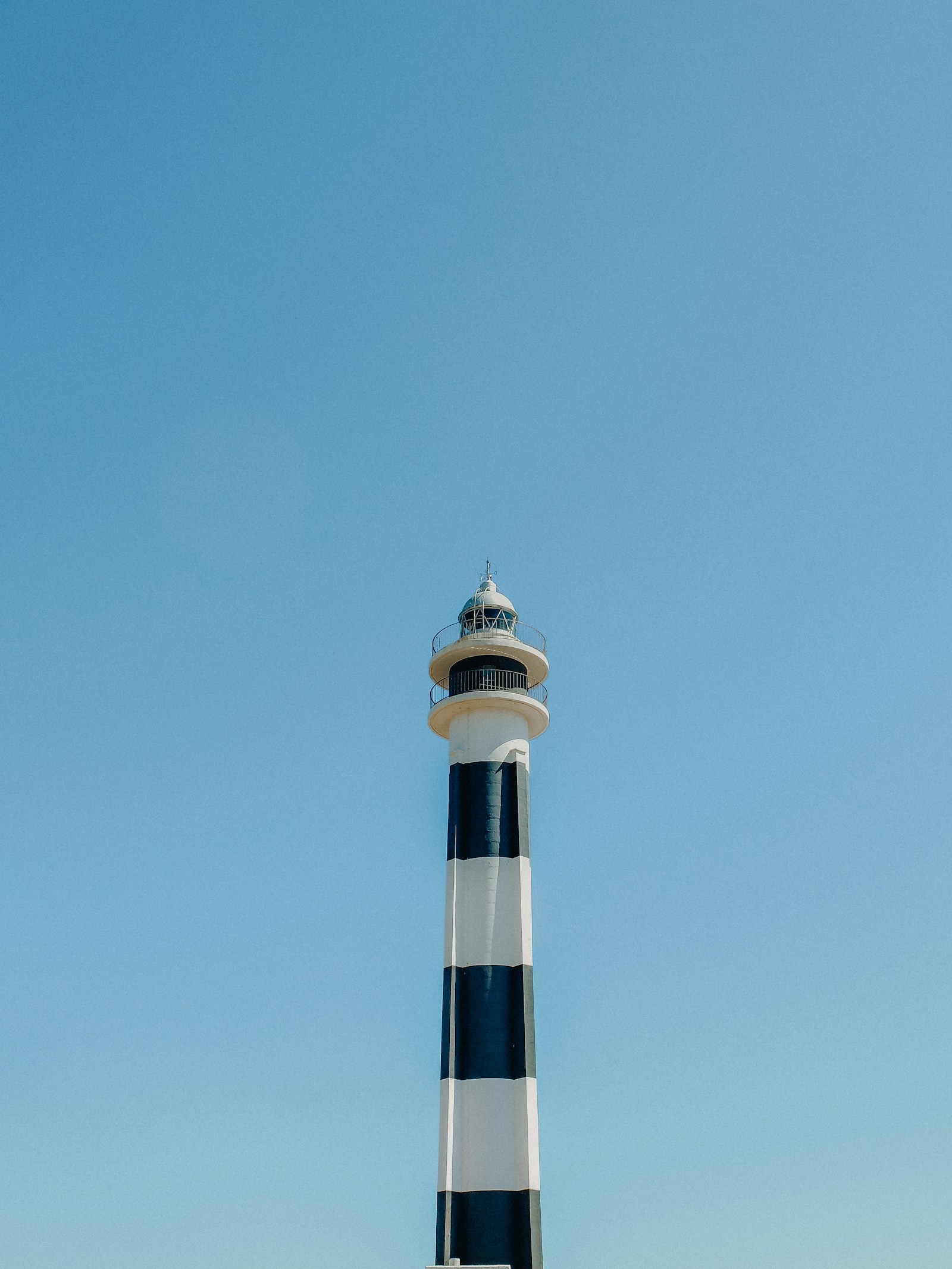 Faro blanco y negro en la costa de Menorca