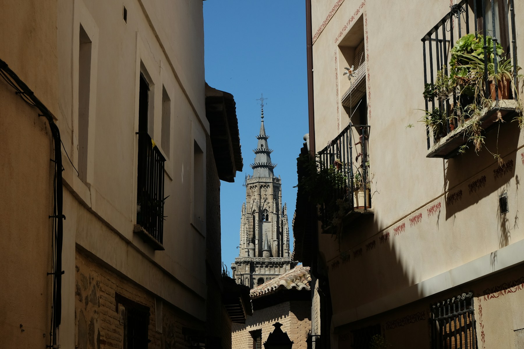 Calle estrecha de Toledo con la torre de la Catedral al fondo