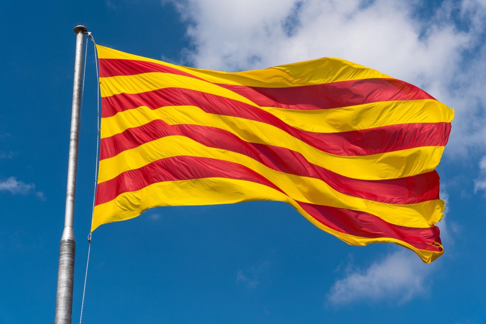 Bandera de Cataluña (senyera) ondeando sobre un cielo azul